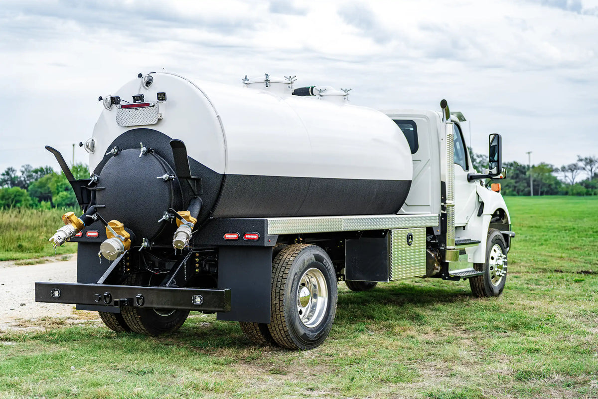 Rear passenger-side of the 2026 International MV-607 2500 Gallon Vacuum Truck for sale from Arkson Truck Co showing the rear-bumper, passenger-side underbody toolbox, and upper access manways