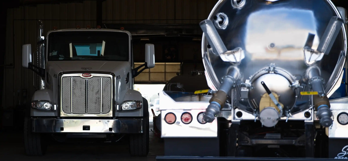 Several Arkson Truck Co custom vocational trucks being built in the shop, including vacuum trucks, hook lift trucks, grapple trucks, septic and sewer pump trucks, portable restroom trucks, and roll off trucks.